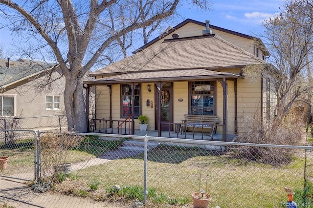 306 E Cannon St, Lafayette, CO 80026 - bungalow-style home featuring covered porch, a fenced front yard, a front yard, roof with shingles, and a gate