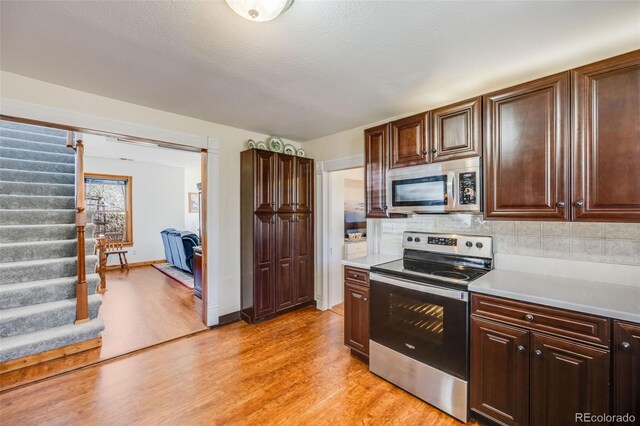 306 E Cannon St, Lafayette, CO 80026 - kitchen featuring light countertops, appliances with stainless steel finishes, decorative backsplash, and light wood-style flooring