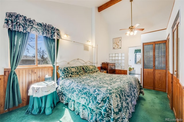 306 E Cannon St, Lafayette, CO 80026 - bedroom with wainscoting, carpet floors, wood walls, a ceiling fan, and beamed ceiling