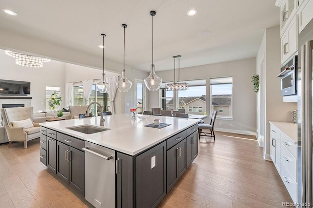 5390 Edenborn Way, Castle Rock, CO 80104 - kitchen featuring stainless steel dishwasher, white cabinetry, light wood-style flooring, light countertops, and a chandelier