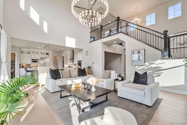 5390 Edenborn Way, Castle Rock, CO 80104 - living area with a chandelier, a towering ceiling, light wood-style floors, and stairway