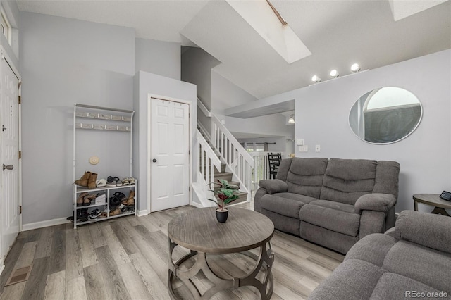 4512 Bramble Ln, Colorado Springs, CO 80925 - living room with a skylight, light wood-style flooring, stairway, and high vaulted ceiling