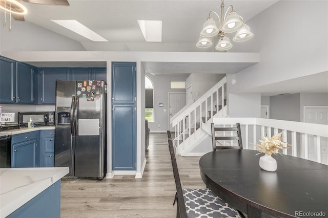 4512 Bramble Ln, Colorado Springs, CO 80925 - kitchen featuring stainless steel refrigerator with ice dispenser, blue cabinets, light wood-style flooring, light countertops, and black microwave