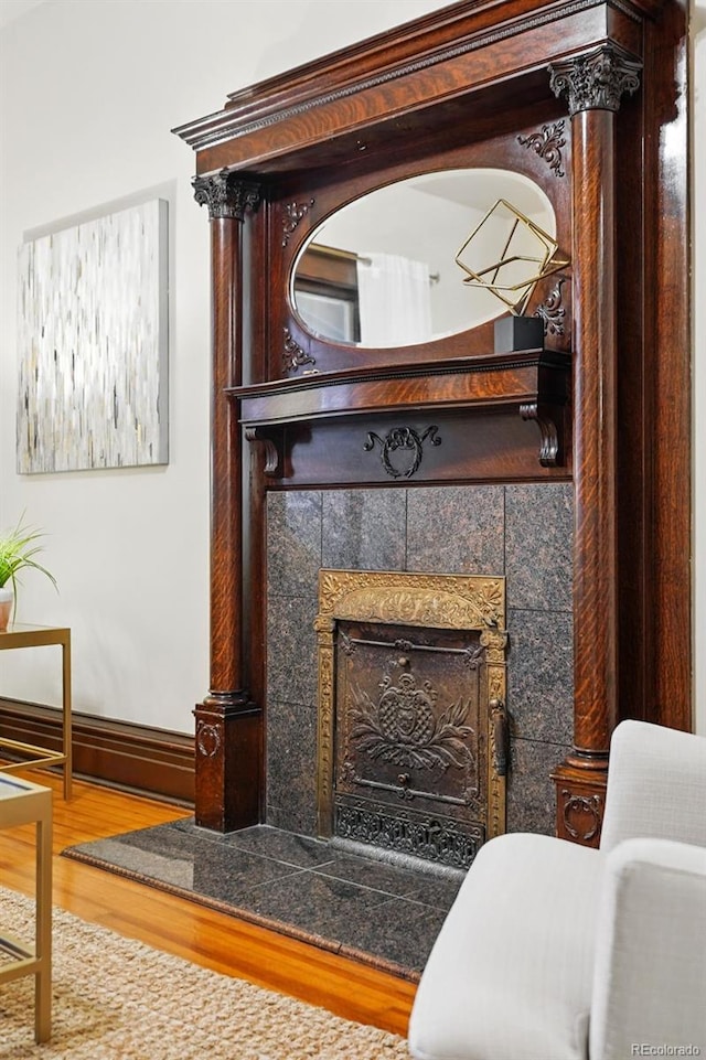 room details featuring wood finished floors, baseboards, and a tile fireplace