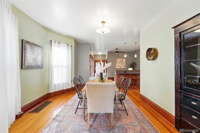 dining area with visible vents, baseboards, and wood finished floors