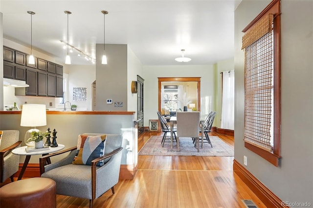 dining room featuring visible vents, baseboards, and light wood-style flooring