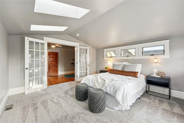 bedroom with visible vents, french doors, vaulted ceiling with skylight, carpet flooring, and baseboards