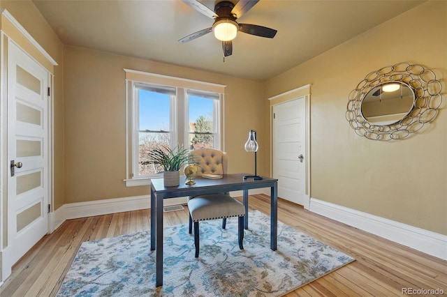 office space with a ceiling fan, light wood-type flooring, and baseboards