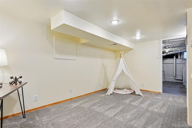 finished basement with visible vents, baseboards, and carpet flooring