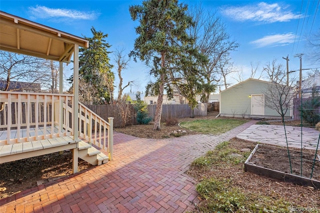 view of patio / terrace with an outdoor structure, a garden, and fence