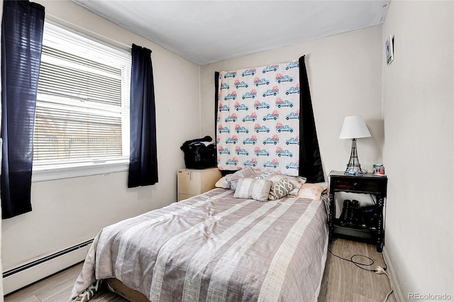 bedroom featuring a baseboard radiator and light hardwood / wood-style flooring