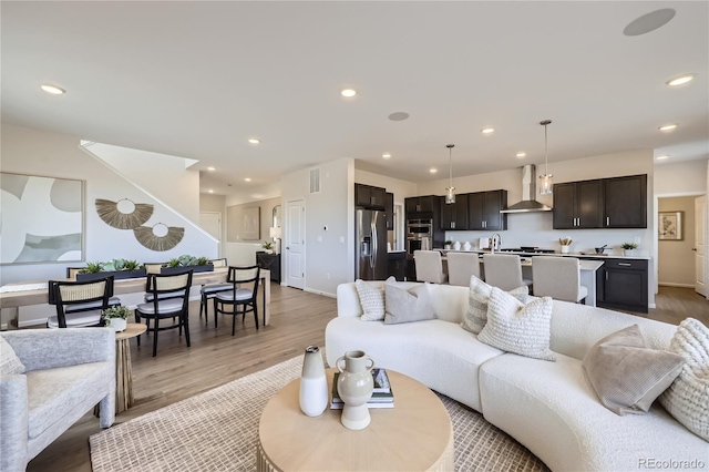 living area with light wood finished floors, baseboards, visible vents, and recessed lighting