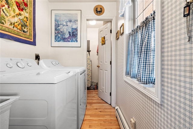 washroom with light wood-type flooring, baseboard heating, separate washer and dryer, and tile walls