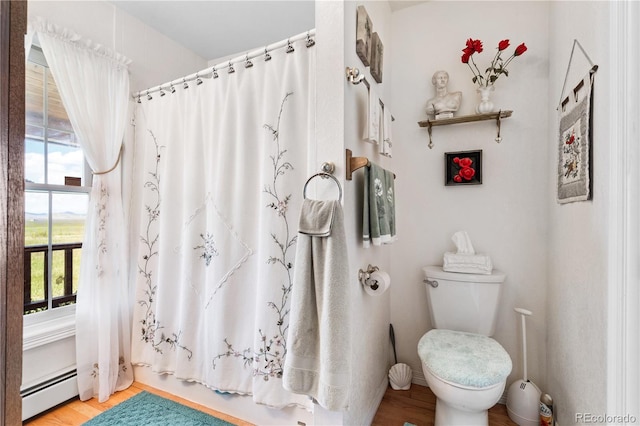 28 County Road 136, Westcliffe, CO 81252 - bathroom featuring wood finished floors, toilet, a shower with shower curtain, and a baseboard radiator