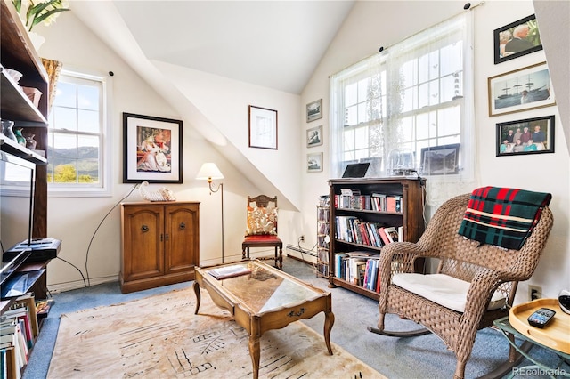 living area with baseboard heating, light colored carpet, and vaulted ceiling