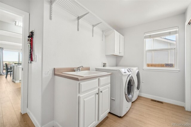 6565 W 99th Ave, Broomfield, CO 80021 - laundry room featuring cabinet space, washer and dryer, a sink, light wood-type flooring, and visible vents