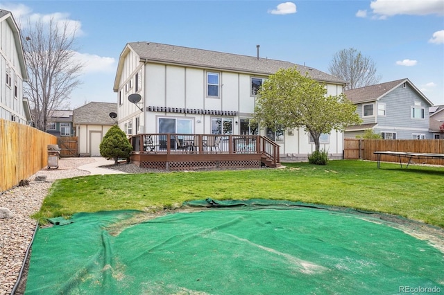 6565 W 99th Ave, Broomfield, CO 80021 - rear view of house with a deck, a fenced backyard, board and batten siding, a trampoline, and a yard