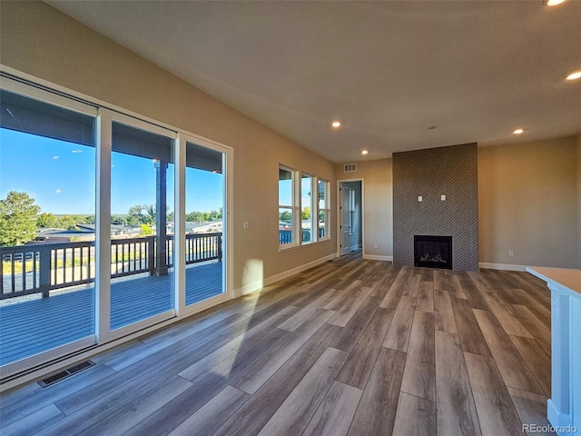 unfurnished living room featuring a large fireplace and hardwood / wood-style floors