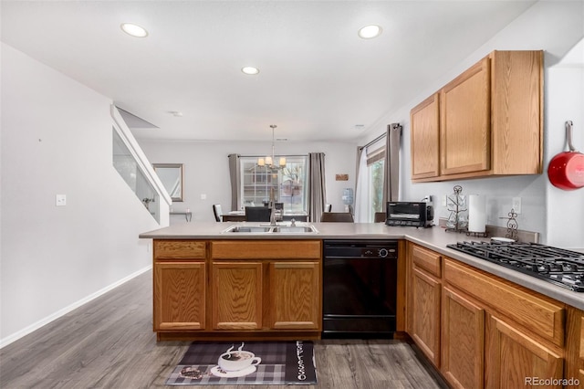 kitchen with kitchen peninsula, sink, an inviting chandelier, dishwasher, and hanging light fixtures