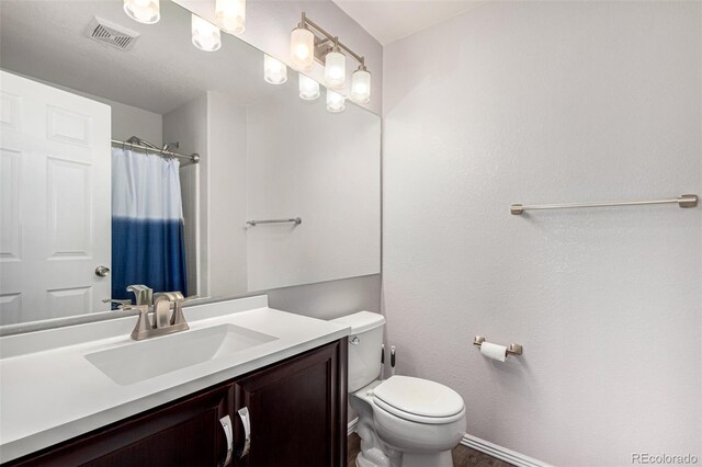 bathroom with a shower with shower curtain, vanity, and toilet