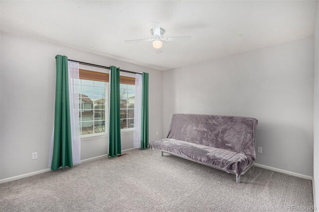 living area featuring carpet flooring and ceiling fan