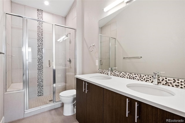 bathroom featuring vanity, an enclosed shower, and toilet