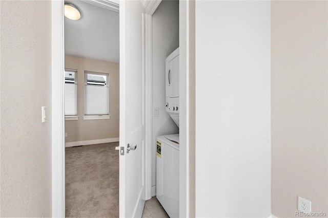 washroom with light carpet and stacked washer / drying machine