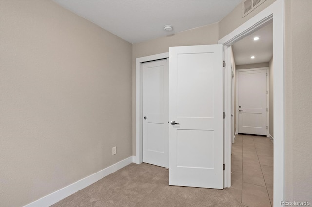 unfurnished bedroom featuring a closet and light colored carpet