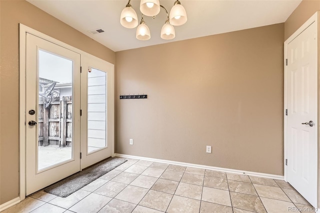 entryway featuring an inviting chandelier and light tile patterned floors