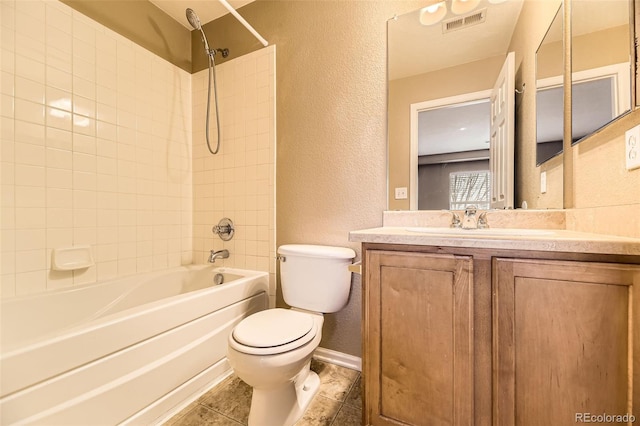 full bathroom with tiled shower / bath, vanity, tile patterned floors, and toilet