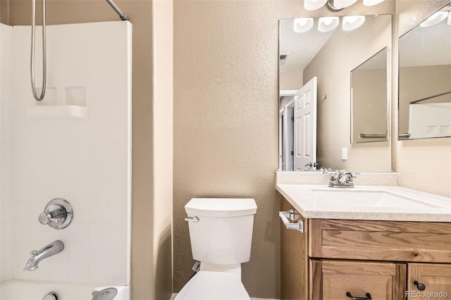 full bathroom with vanity, tiled shower / bath combo, and toilet