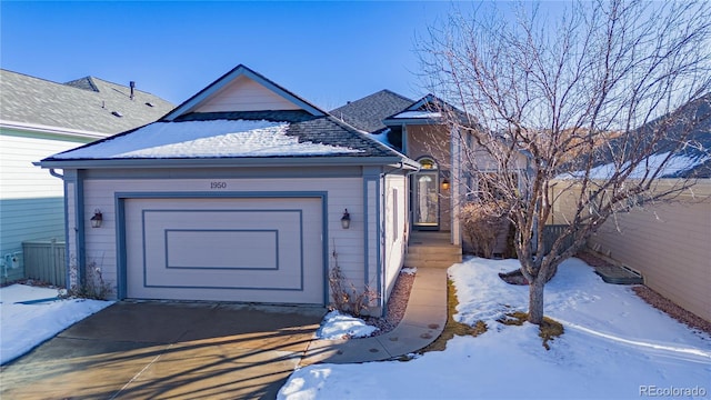 snow covered property entrance with a garage