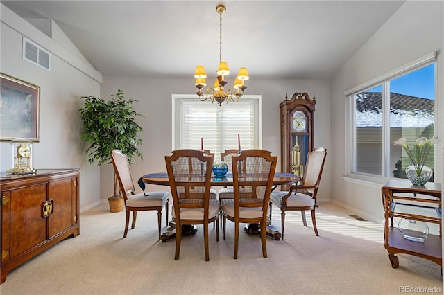 carpeted dining area featuring an inviting chandelier and vaulted ceiling