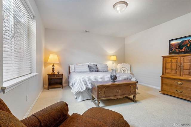 bedroom featuring multiple windows and light colored carpet