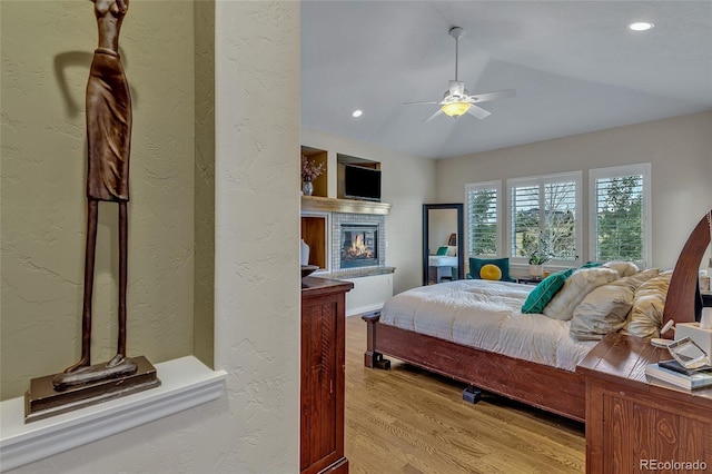 bedroom featuring ceiling fan, vaulted ceiling, and light wood-type flooring