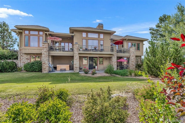 back of house with a balcony, a jacuzzi, a yard, and a patio area