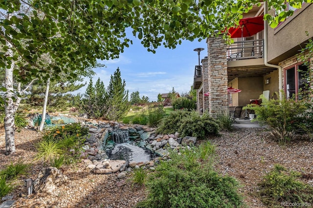 view of yard featuring a balcony and a patio area