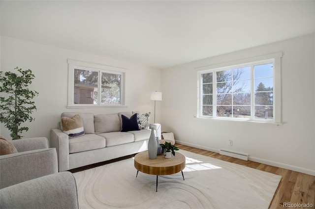 living area with a wealth of natural light, baseboards, and wood finished floors