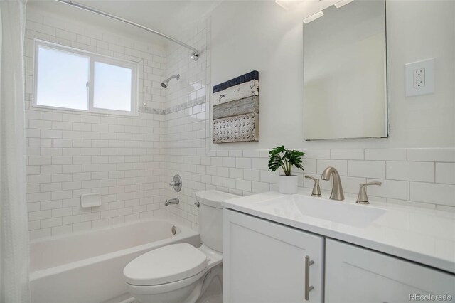 bathroom featuring toilet, backsplash, shower / bathtub combination with curtain, vanity, and tile walls