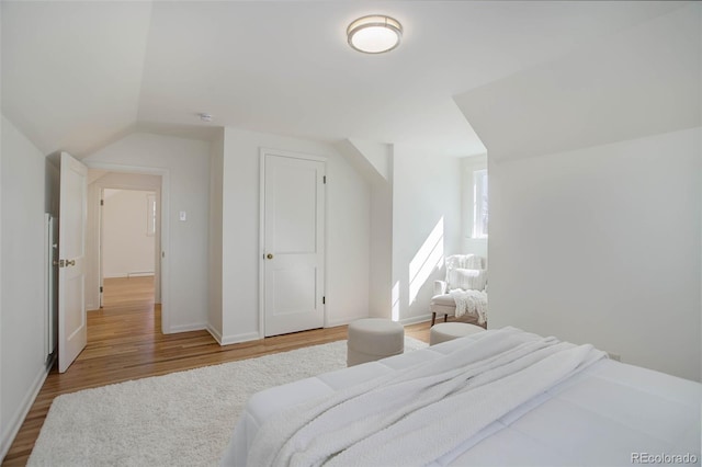 bedroom featuring lofted ceiling and wood finished floors