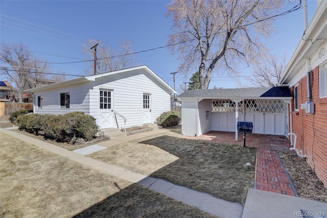 view of home's exterior featuring entry steps, an outdoor structure, and fence