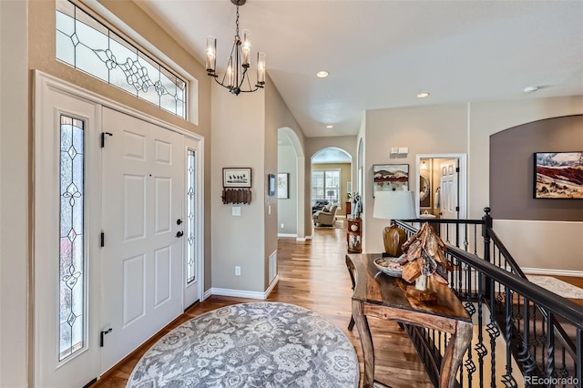 foyer entrance with a notable chandelier and light hardwood / wood-style flooring