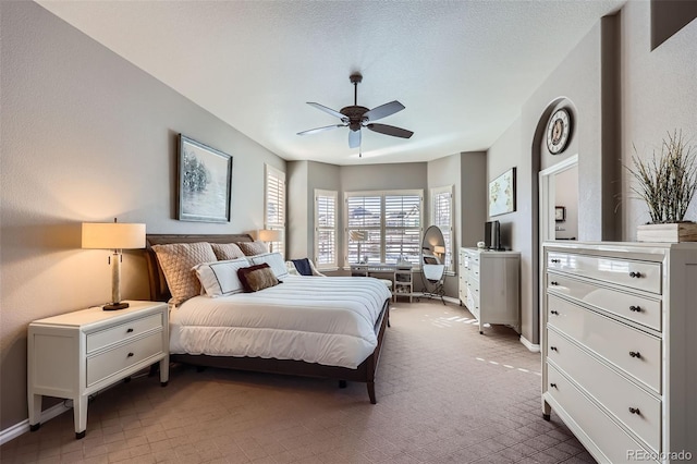 carpeted bedroom featuring a textured ceiling and ceiling fan