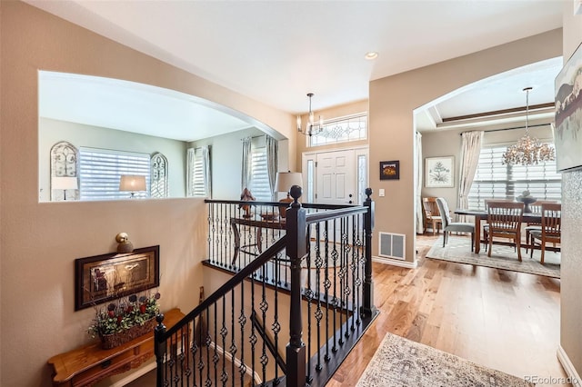 entryway with hardwood / wood-style flooring, plenty of natural light, and a chandelier