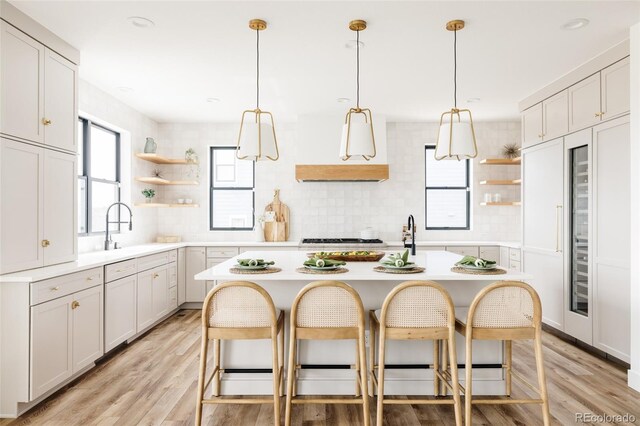 17252 Rose Mallow Ave, Parker, CO 80134 - kitchen featuring open shelves, a sink, light countertops, a kitchen breakfast bar, and decorative backsplash