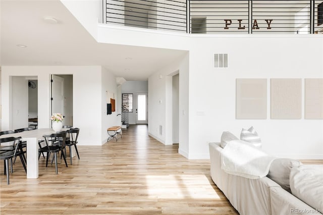 17252 Rose Mallow Ave, Parker, CO 80134 - living area featuring light wood finished floors, baseboards, visible vents, and a towering ceiling