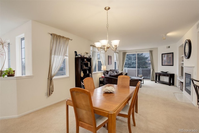 dining space featuring light colored carpet and an inviting chandelier