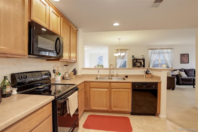 kitchen with black appliances, decorative light fixtures, light brown cabinetry, sink, and kitchen peninsula