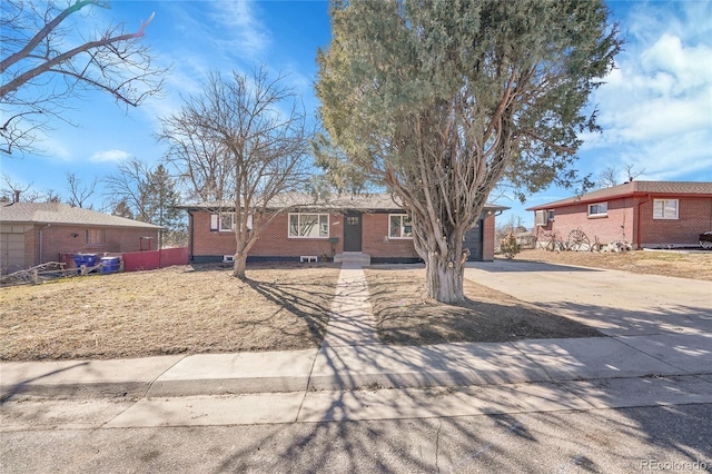 single story home featuring driveway, brick siding, and fence