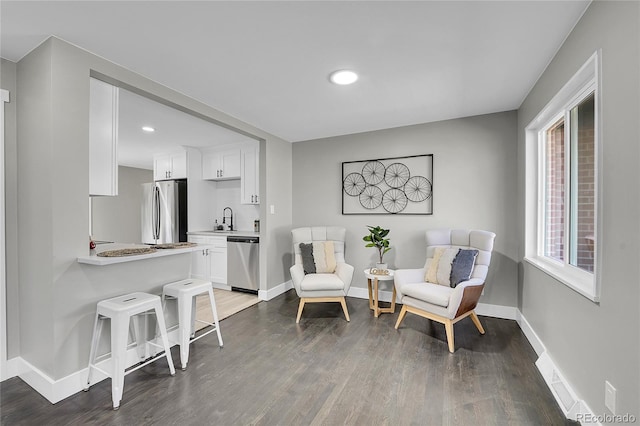 living area with baseboards, dark wood-style flooring, and recessed lighting